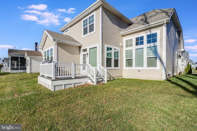 rear view of property featuring a lawn and a wooden deck