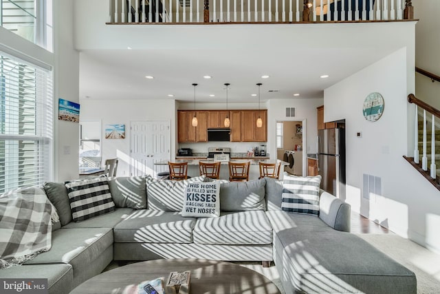 living room with a towering ceiling, wood-type flooring, and washer / dryer