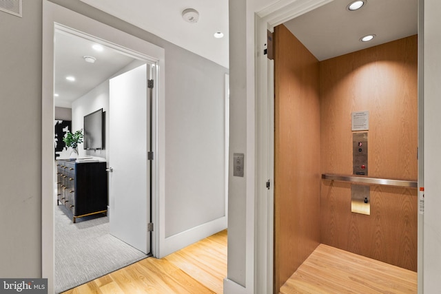 bathroom with hardwood / wood-style flooring and elevator