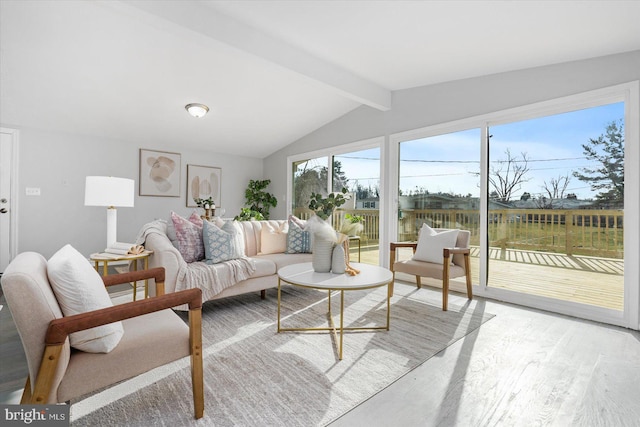 sunroom featuring lofted ceiling with beams