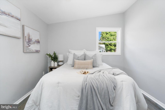 bedroom with dark hardwood / wood-style floors and lofted ceiling