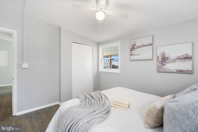 bedroom featuring ceiling fan, a closet, dark wood-type flooring, and lofted ceiling