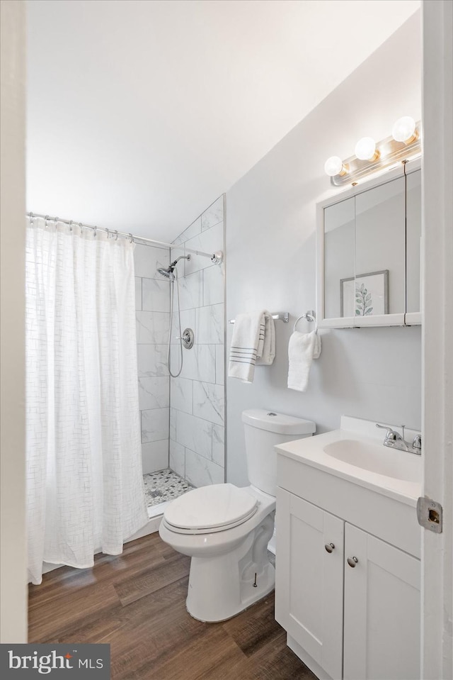 bathroom featuring hardwood / wood-style floors, vanity, toilet, and walk in shower