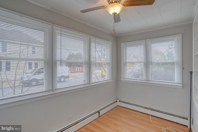 unfurnished sunroom featuring baseboard heating and ceiling fan