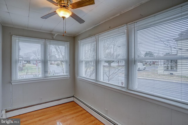 unfurnished sunroom with baseboard heating and ceiling fan