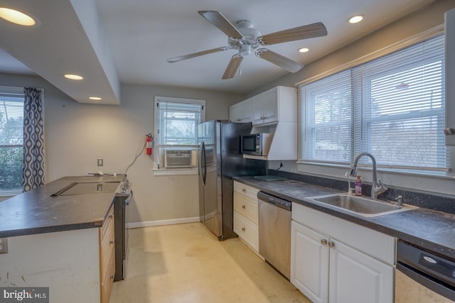 kitchen featuring a wealth of natural light, white cabinetry, sink, and appliances with stainless steel finishes