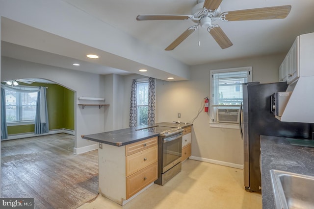 kitchen featuring kitchen peninsula, appliances with stainless steel finishes, light wood-type flooring, and a wealth of natural light