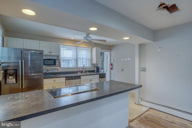 kitchen with appliances with stainless steel finishes, baseboard heating, sink, light hardwood / wood-style flooring, and white cabinets