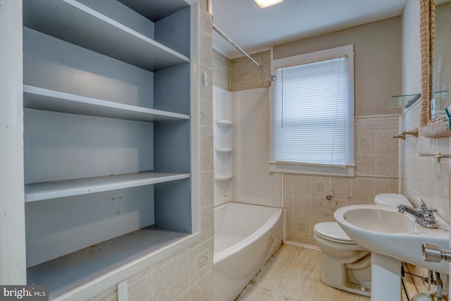 bathroom with shower / bath combination, tile walls, and toilet