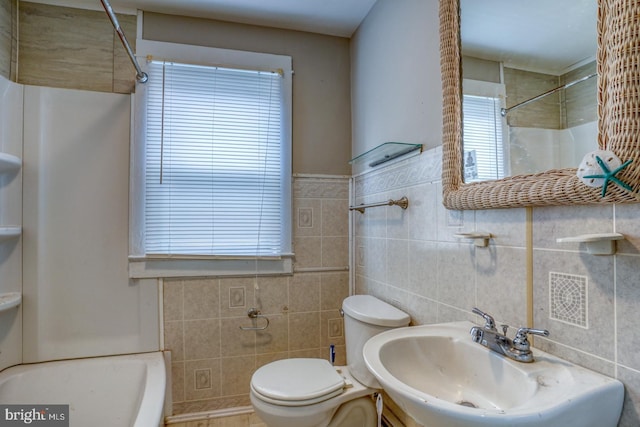 full bathroom featuring toilet,  shower combination, sink, and tile walls