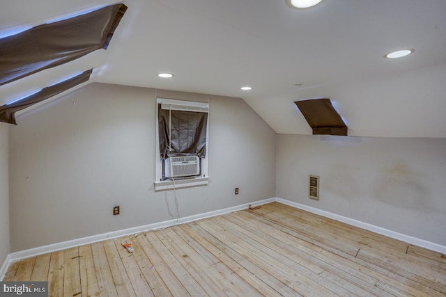 additional living space featuring light hardwood / wood-style floors, cooling unit, and lofted ceiling