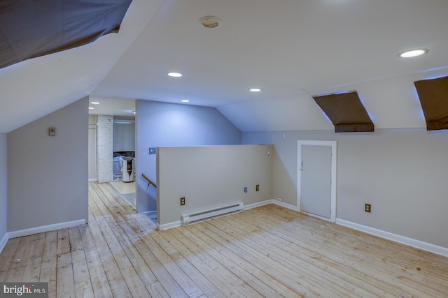 bonus room featuring vaulted ceiling, light wood-type flooring, and a baseboard heating unit