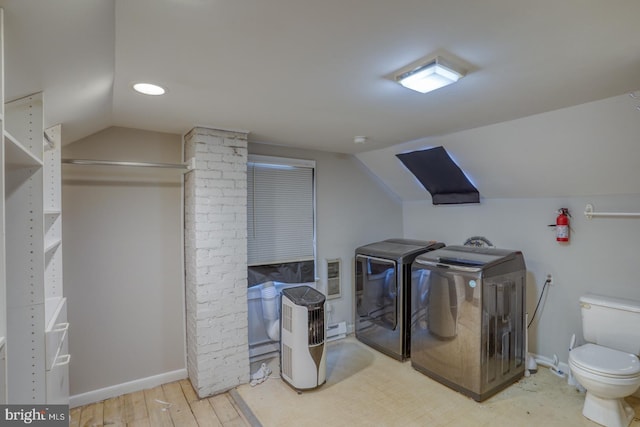 laundry area with hardwood / wood-style flooring, heating unit, and washing machine and clothes dryer