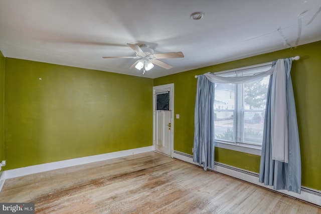 spare room featuring ceiling fan, light hardwood / wood-style flooring, and a baseboard heating unit