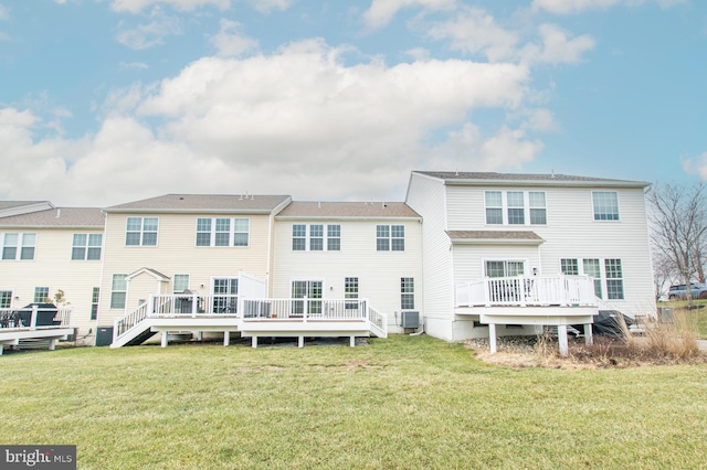 back of property with a lawn, a wooden deck, and central AC