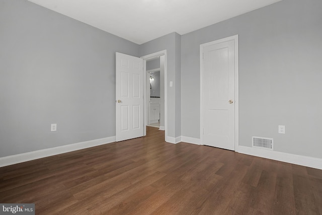 unfurnished bedroom with dark wood-type flooring