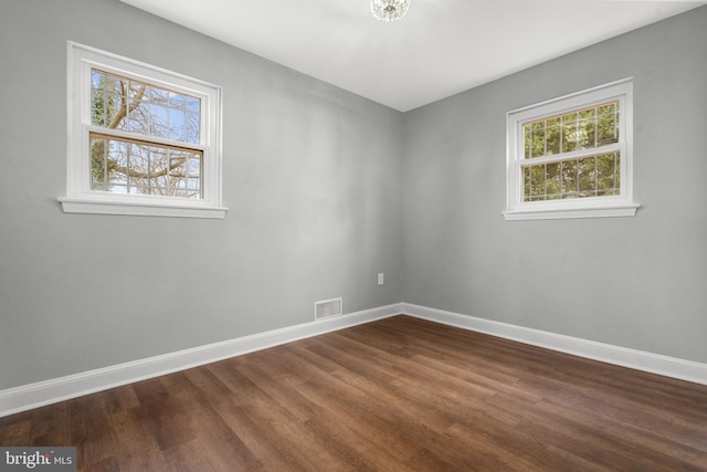 unfurnished room with dark wood-type flooring