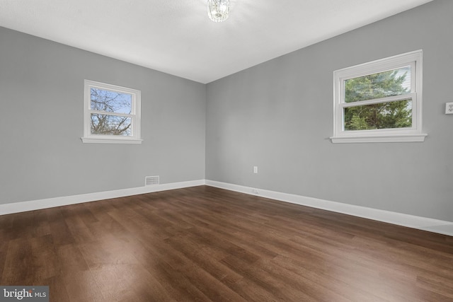 spare room with dark hardwood / wood-style flooring