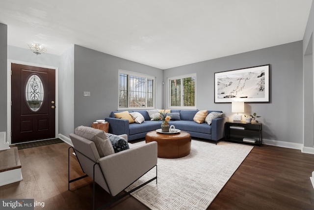 living room with dark wood-type flooring and an inviting chandelier