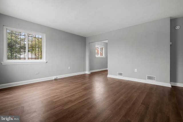 empty room with dark hardwood / wood-style flooring