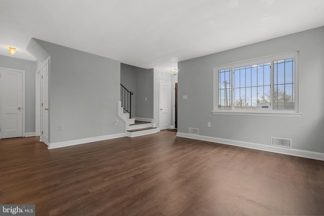 unfurnished living room with dark wood-type flooring