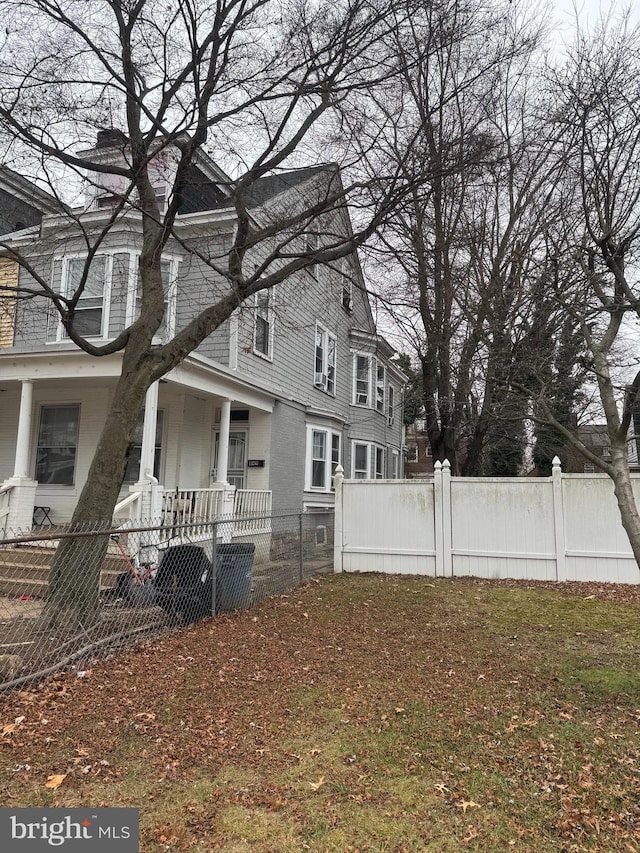 view of side of property featuring covered porch