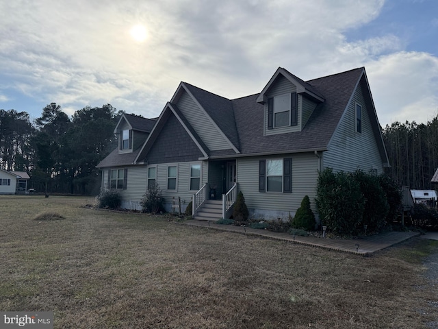 view of front of house with a front yard and a shingled roof