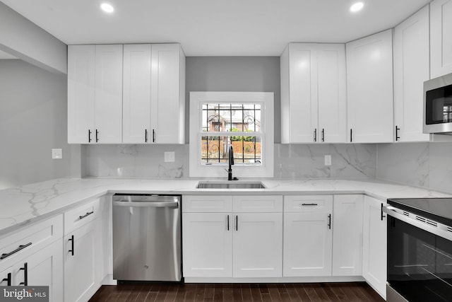 kitchen featuring white cabinets, appliances with stainless steel finishes, dark hardwood / wood-style floors, and sink