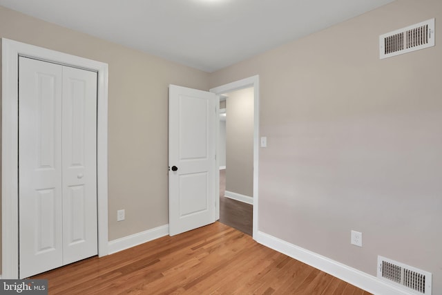 unfurnished bedroom featuring a closet and light hardwood / wood-style flooring