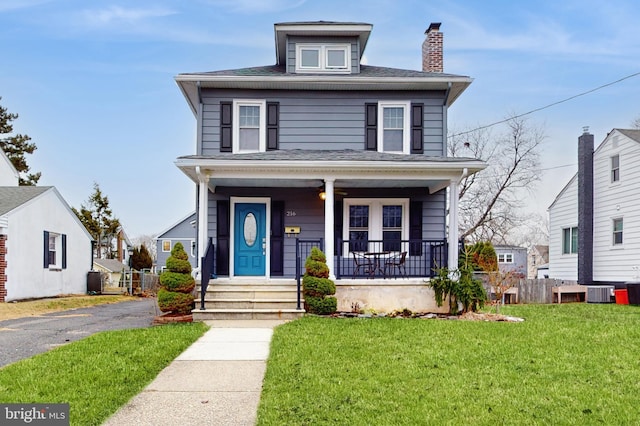 view of front of home with central AC unit, a front lawn, and a porch