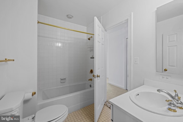 full bathroom featuring tile patterned flooring, vanity, tiled shower / bath combo, and toilet