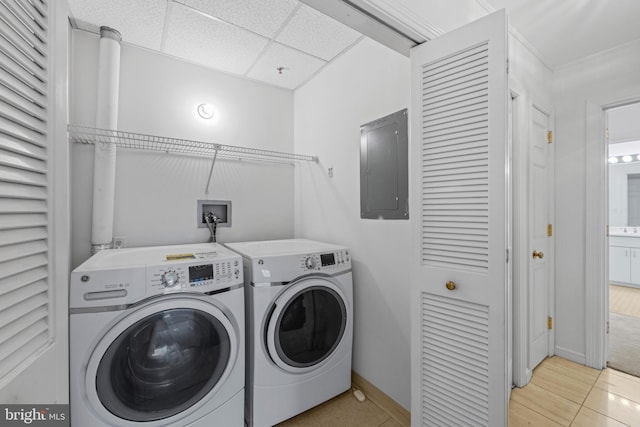 clothes washing area with light tile patterned floors, independent washer and dryer, and electric panel