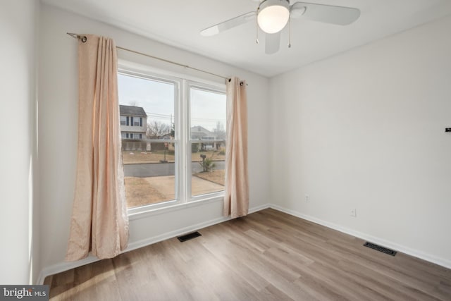 unfurnished room with light hardwood / wood-style flooring, a wealth of natural light, and ceiling fan