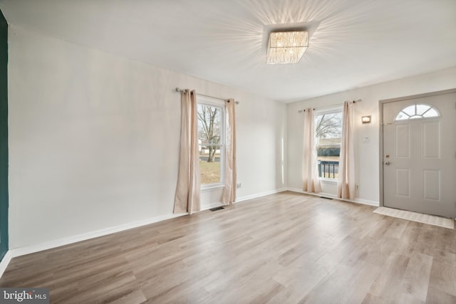 entrance foyer featuring light hardwood / wood-style flooring and a chandelier