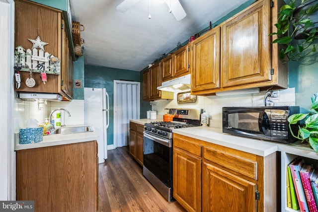 kitchen with gas stove, sink, dark wood-type flooring, tasteful backsplash, and white refrigerator