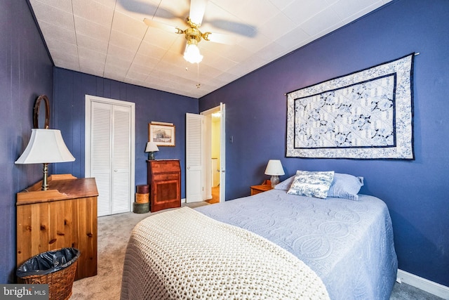 bedroom with a closet, ceiling fan, and light colored carpet