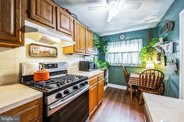 kitchen with ceiling fan, gas stove, dark hardwood / wood-style flooring, and backsplash