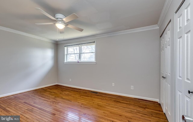 unfurnished bedroom featuring wood-type flooring, ceiling fan, and crown molding