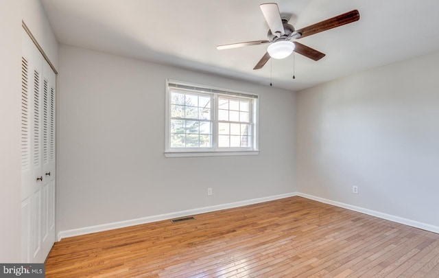 unfurnished bedroom featuring ceiling fan, light wood-type flooring, and a closet