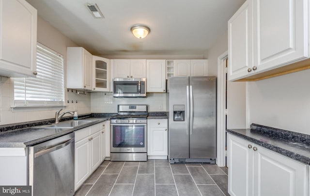 kitchen featuring backsplash, sink, white cabinets, and appliances with stainless steel finishes