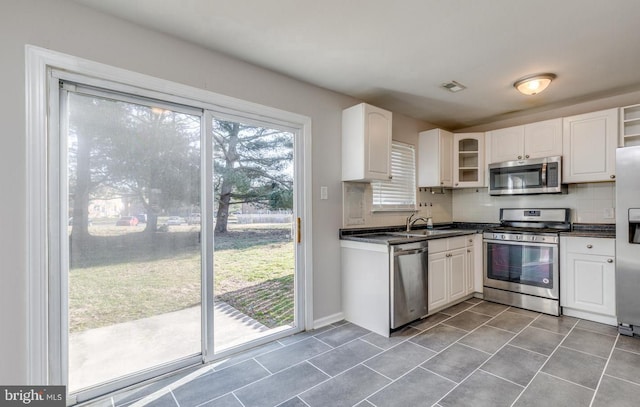 kitchen featuring white cabinets, sink, stainless steel appliances, and tasteful backsplash