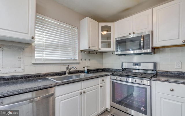 kitchen with tasteful backsplash, white cabinetry, sink, and appliances with stainless steel finishes