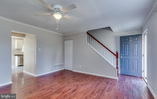 foyer with a textured ceiling, ceiling fan, wood-type flooring, and ornamental molding