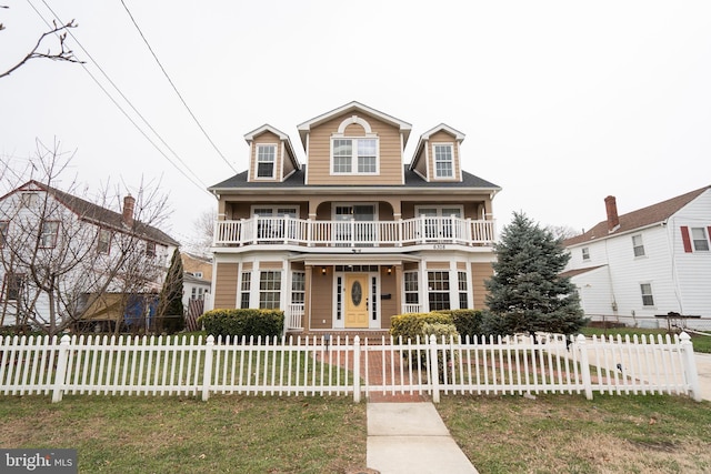 view of front facade with a porch, a balcony, and a front yard