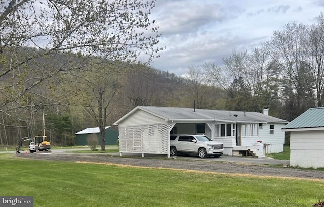 view of front facade with a carport and a front yard