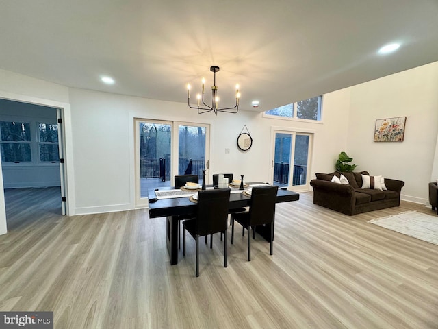 dining room with light hardwood / wood-style floors and a chandelier