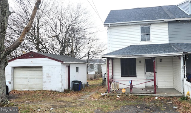 view of front of property featuring covered porch, a garage, and an outdoor structure