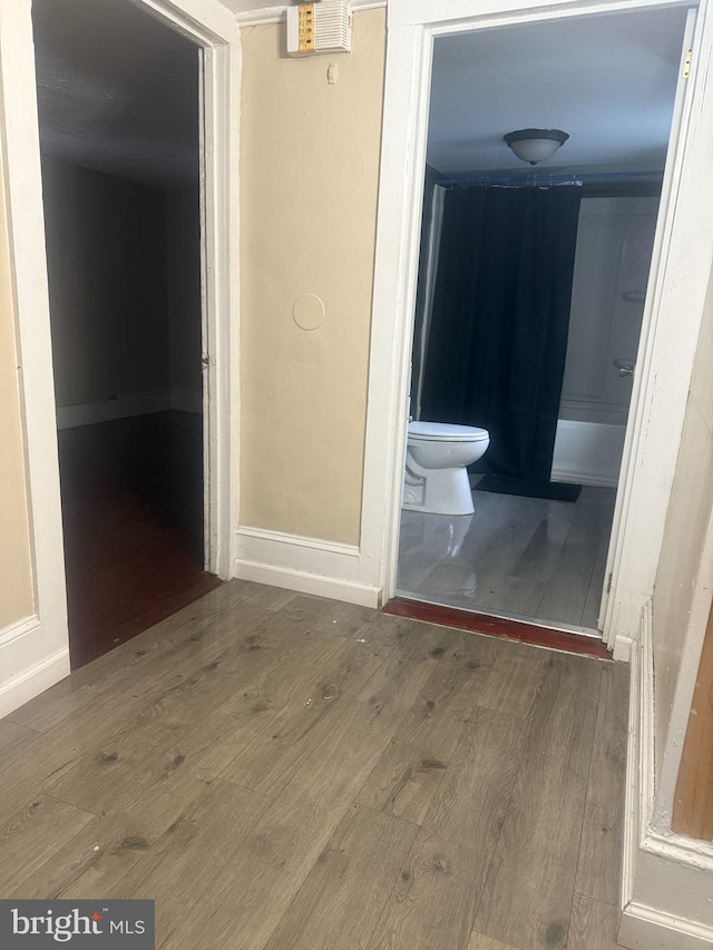 bathroom with toilet, bathtub / shower combination, and hardwood / wood-style flooring