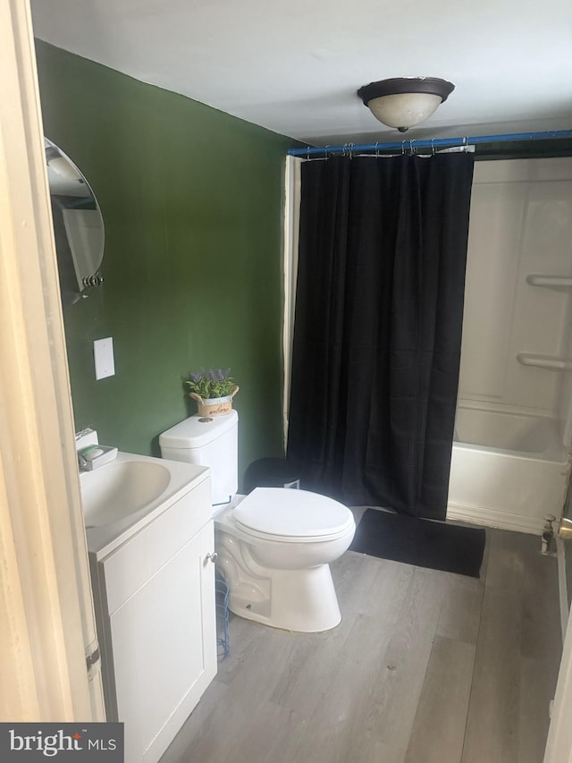 full bathroom featuring shower / bath combination with curtain, vanity, hardwood / wood-style flooring, and toilet