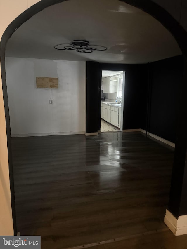 spare room featuring sink and dark wood-type flooring